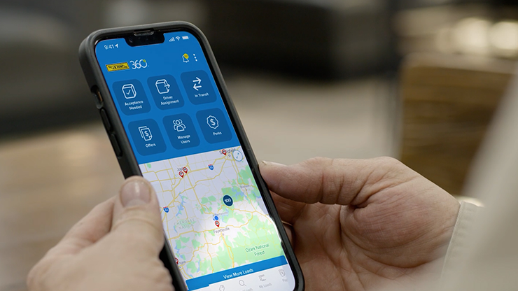 person holding phone with J.B. Hunt 360 platform on screen