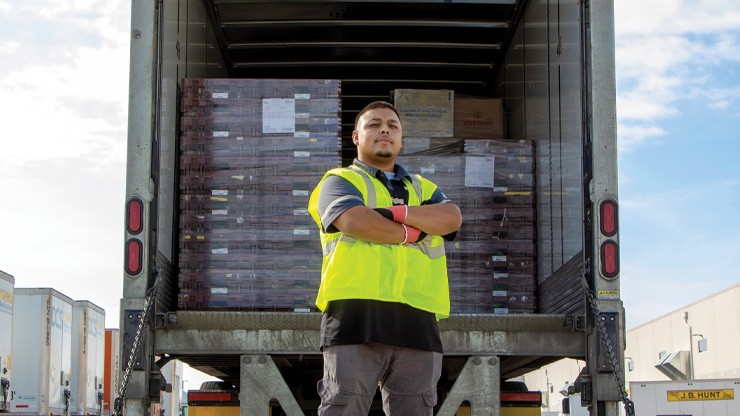 J.B. Hunt Dedicated Contract Services driver standing behind truck