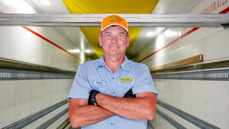 Photo of J.B. Hunt driver standing inside a semi trailer
