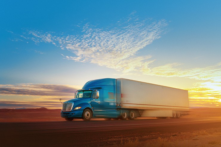 Blue and white semi-truck speeding on a single lane road USA
