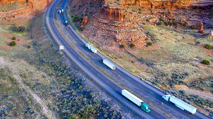 dedicated fleet management trucks driving down a mountain highway