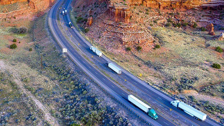 dedicated fleet management trucks driving down a mountain highway
