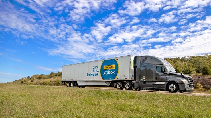 A semi-truck with 360box container travels on an open highway