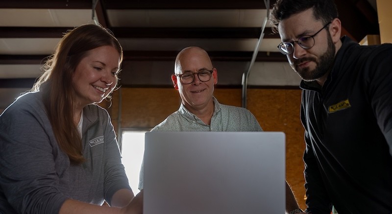 j.b. employee meeting with employee in their warehouse around a laptop