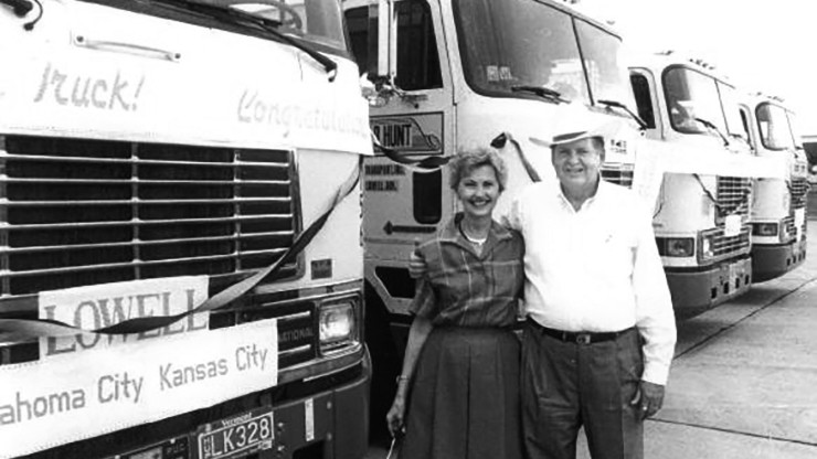 historic photo of mr. and mrs. hunt in front of j.b. hunt trucks