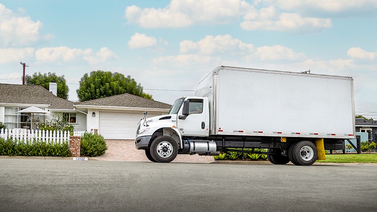 a straight truck is parked in front of a house