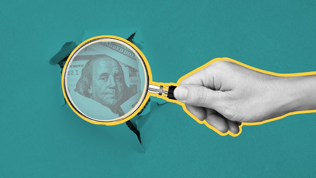 digital image of a one hundred dollar bill breaking through a green foreground under a magnifying glass