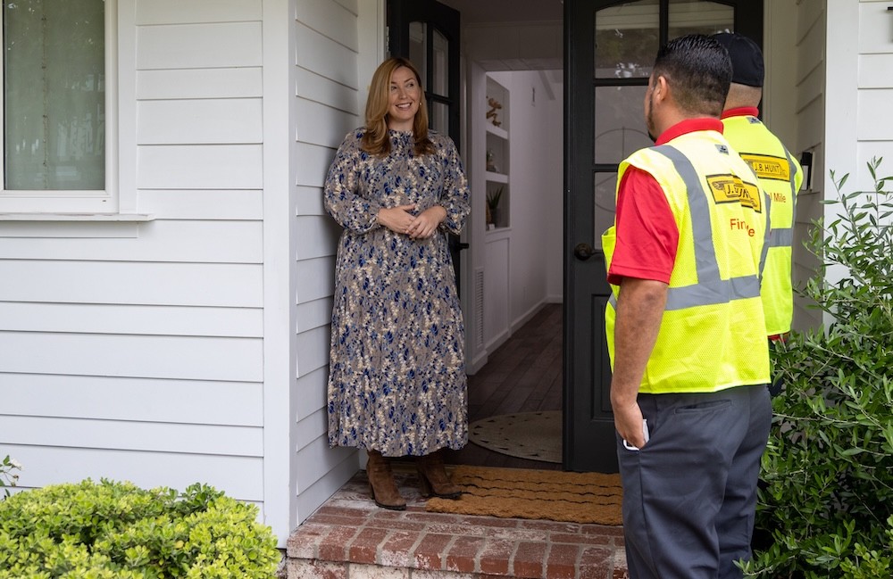 Two Final Mile Delivery Service team members from J.B. Hunt speak with a homeowner at the front door during a scheduled home furniture delivery.