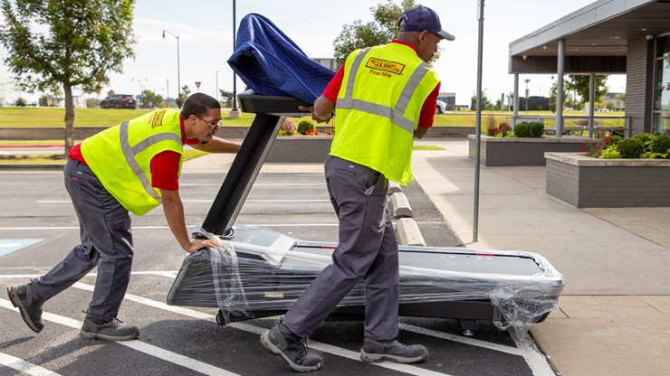 workers moving a treadmill