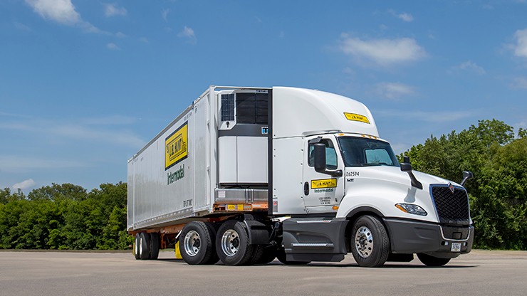 A J.B. Hunt temperature-controlled intermodal truck and trailer parked in an empty lot.