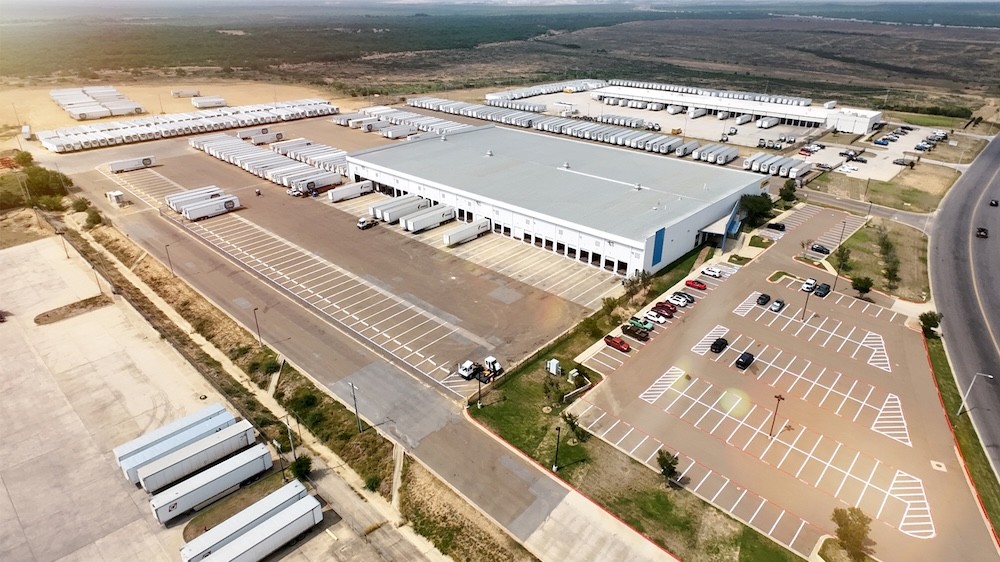 Aerial view of a large cross-border warehousing and distribution center in Laredo Texas with truck trailers, loading docks, and parking areas supporting freight warehousing and transloading operations near the U.S.-Mexico border.