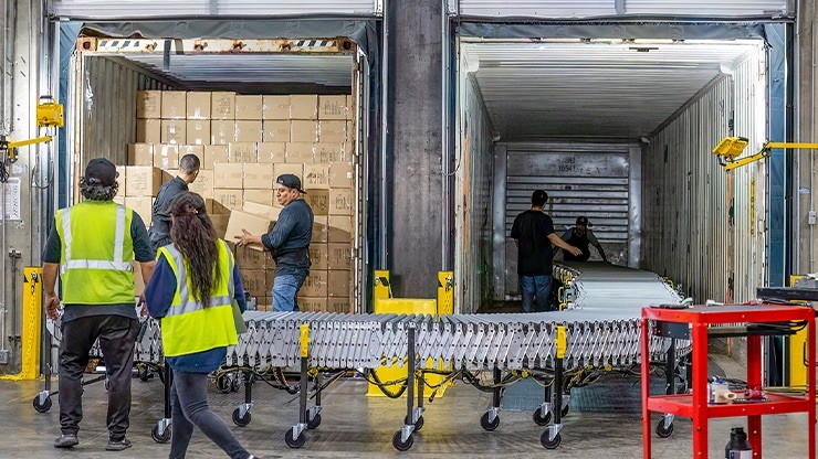 warehouse workers transloading boxes between containers