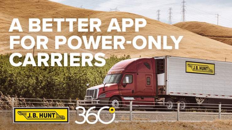A J.B. Hunt tractor trailer travels down a road under a row of hills
