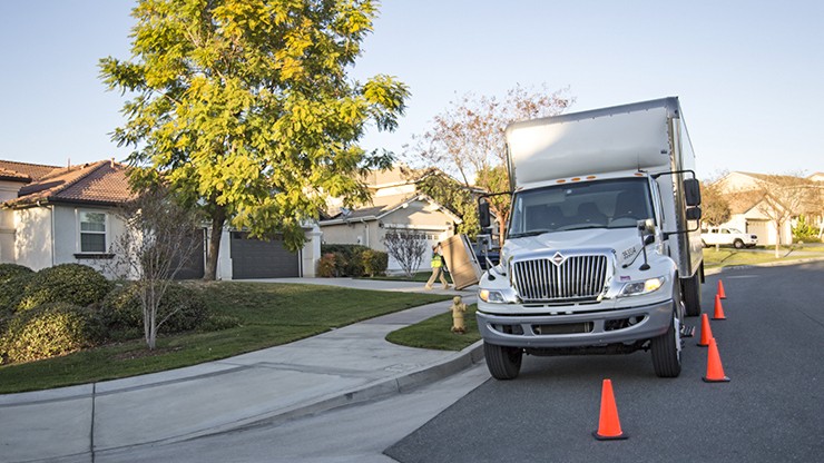 straight truck in front of house with cones