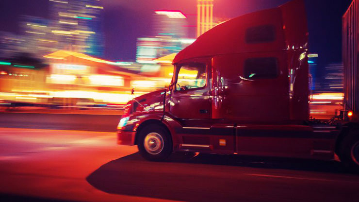 tractor trailer truck on a city highway at night