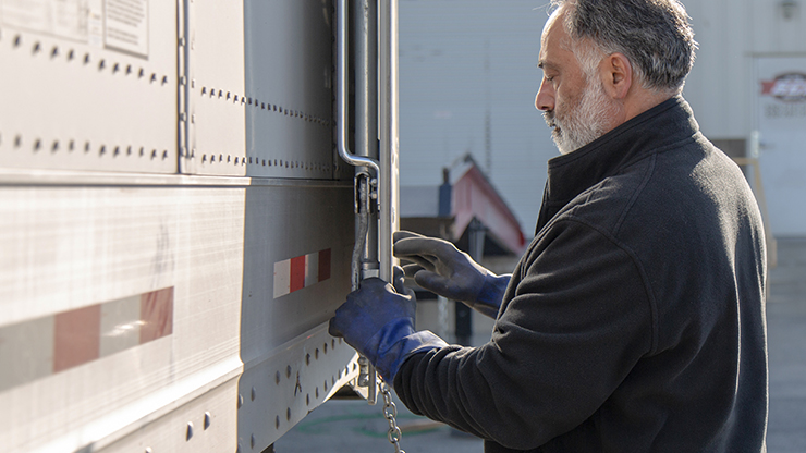 A J.B. Hunt driver closes and locks the doors on a semi trailer
