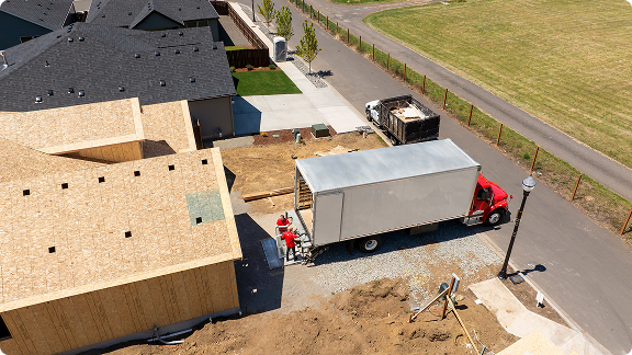employees unloading a truck on a construction site