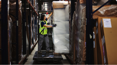 worker moving a couch in a warehouse