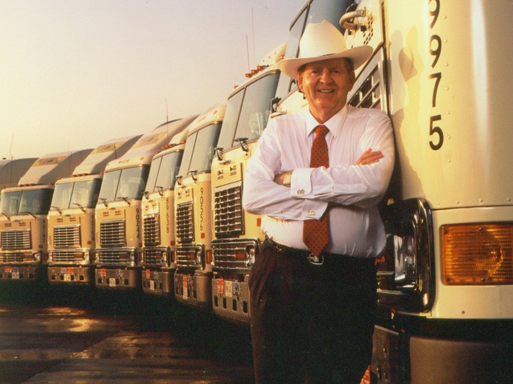 Founder J.B. Hunt standing with trucks