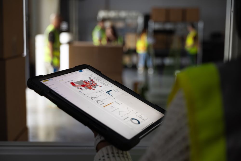 employee holding ipad tracking freight in a warehouse