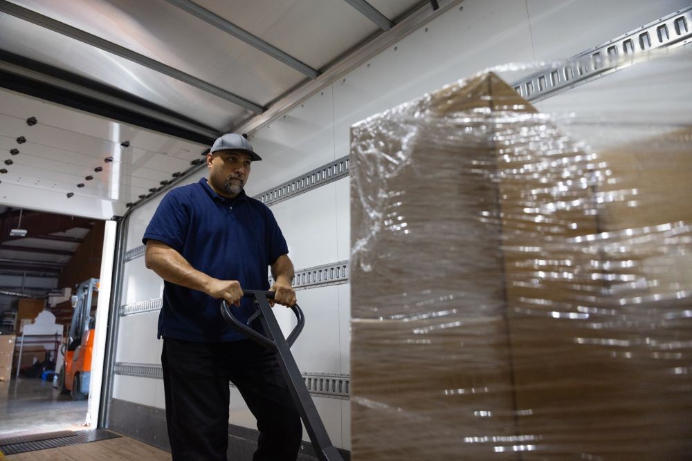 Worker loading pallets on a truck