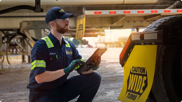 A J.B. Hunt employee inspecting a truck