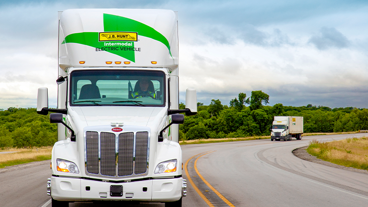 photo of electric intermodal semi truck traveling down a two lane highway