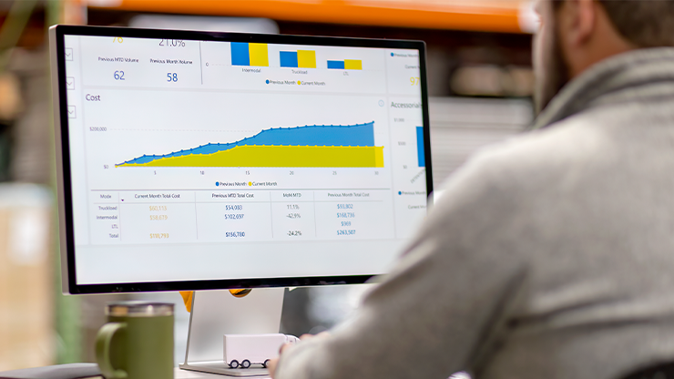An individual looks a a computer monitor that is displaying charts and graphs