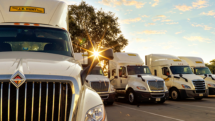 Photo of white semi trucks parked in a lot