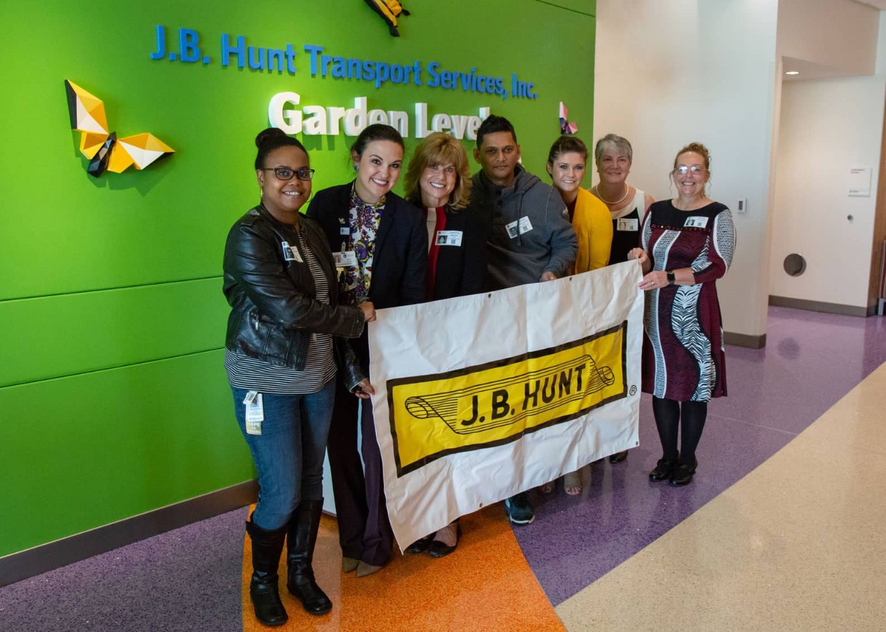 Group of J.B. Hunt employees holding a J.B. Hunt banner