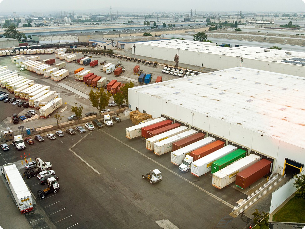 Aerial view of a warehouse distribution center with trucks and trailers at loading docks