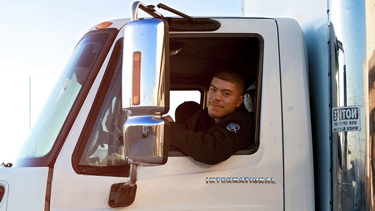 Driver smiling out of his truck's drivers-side window.