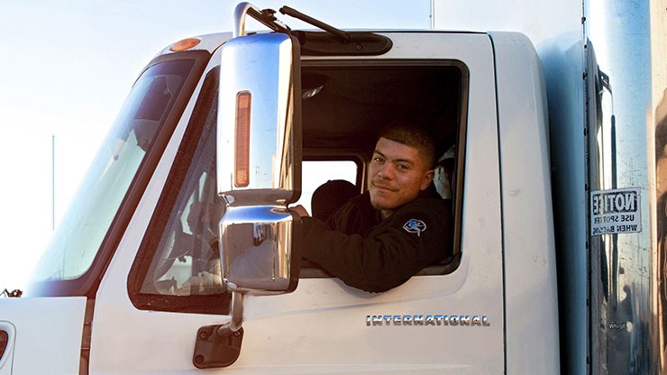Driver smiling out of his truck's drivers-side window. Driver smiling out of his truck's drivers-side window.