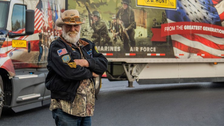 Veteran driver standing next to J.B. Hunt tractor trailer