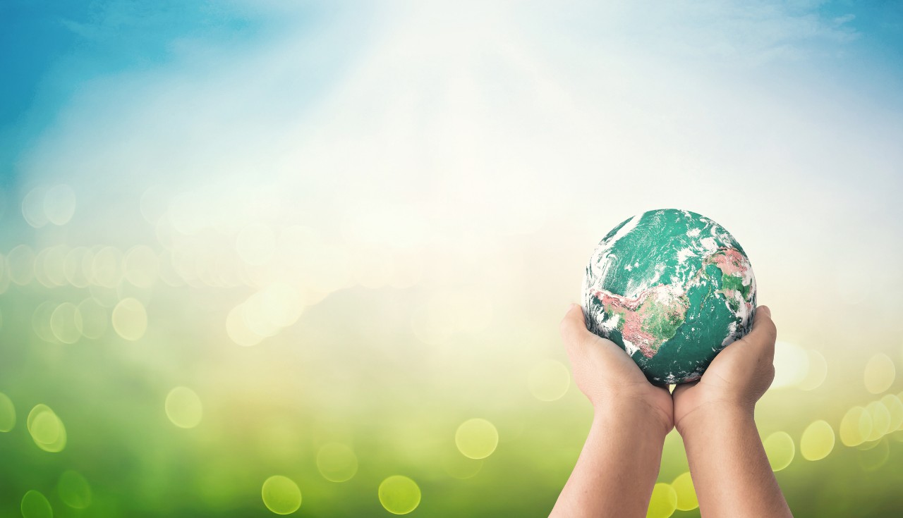 1175471797 Human hands holding earth global on blurred green nature background. Elements of this image furnished by NASA