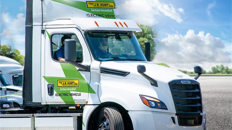 J.B. Hunt Intermodal Electric Vehicle A white J.B. Hunt electric truck in a parking lot on a sunny day