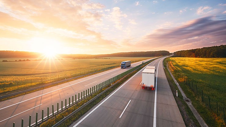 trucks on a road during sunrise