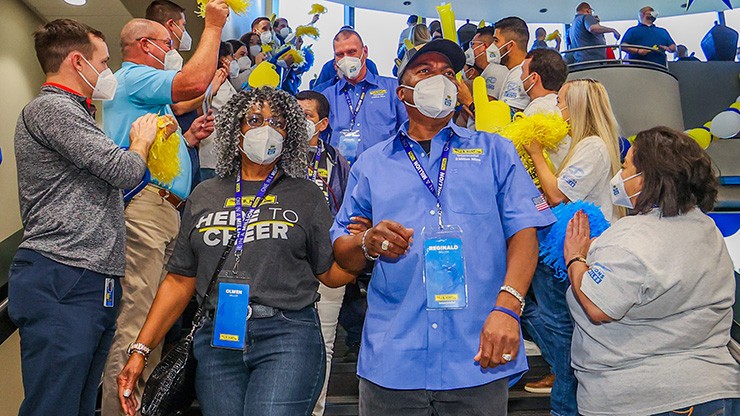 drivers and family descend staircase to cheers and applause at J.B. Hunt Headquarters