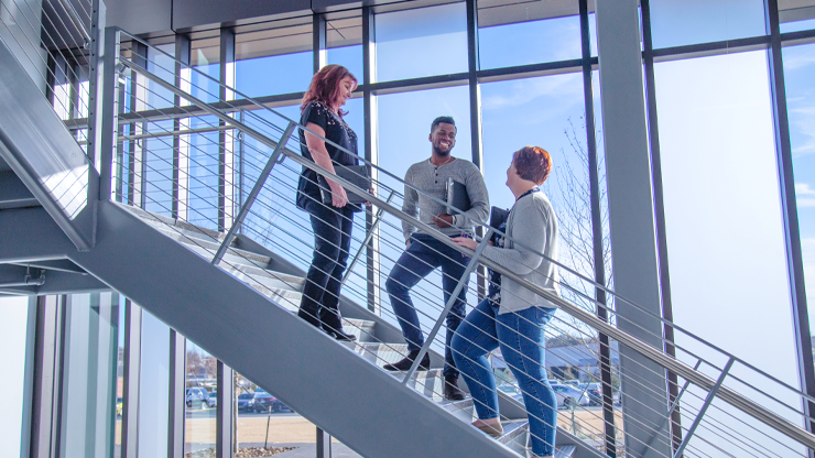 employees on staircase photo of J.B. Hunt employees conversing on stairs of corporate office