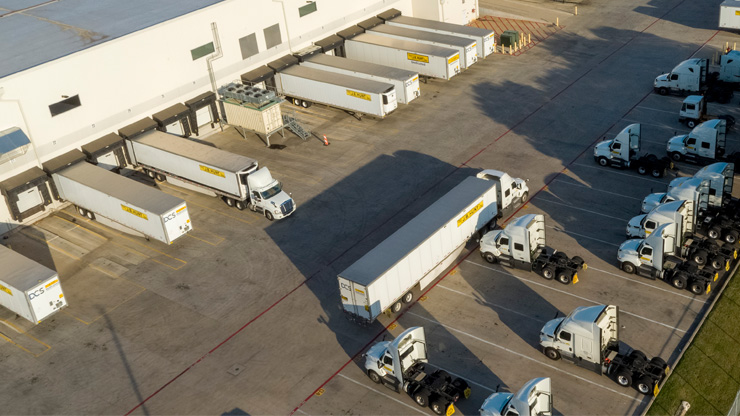 J.B. Hunt tractor trailers parked outside of a loading dock