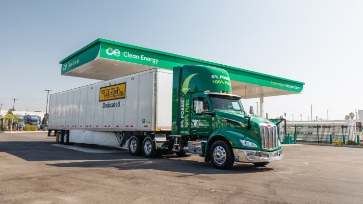 environmentally friendly truck in front of a filling station environmentally friendly truck in front of a filling station