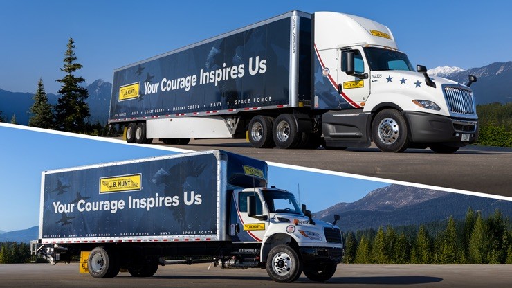 Two J.B. Hunt trucks wrapped with the message “Your Courage Inspires Us” honoring military service, photographed against a backdrop of mountains and forests.