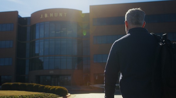 Man walking up to the J.B. Hunt corporate office. 