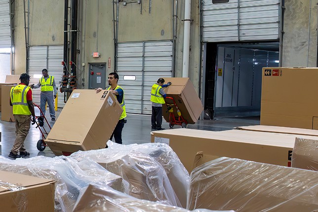 Workers unloading cargo at a warehouse. 