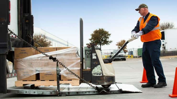 Photo of a J.B. Hunt driver moving boxes with a pallet jack