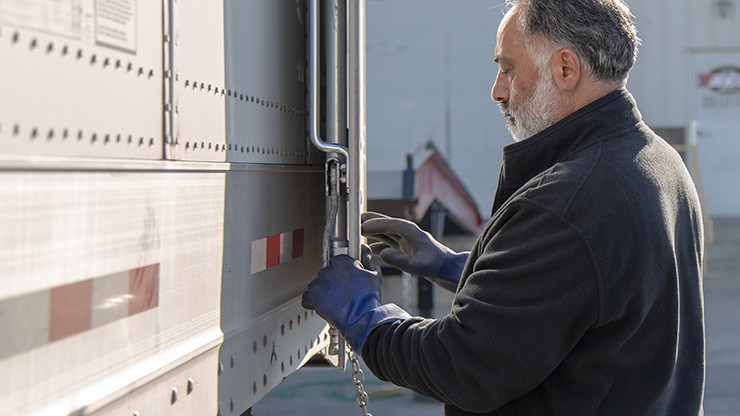 Photo of J.B. Hunt driver closing the doors on a semi trailer